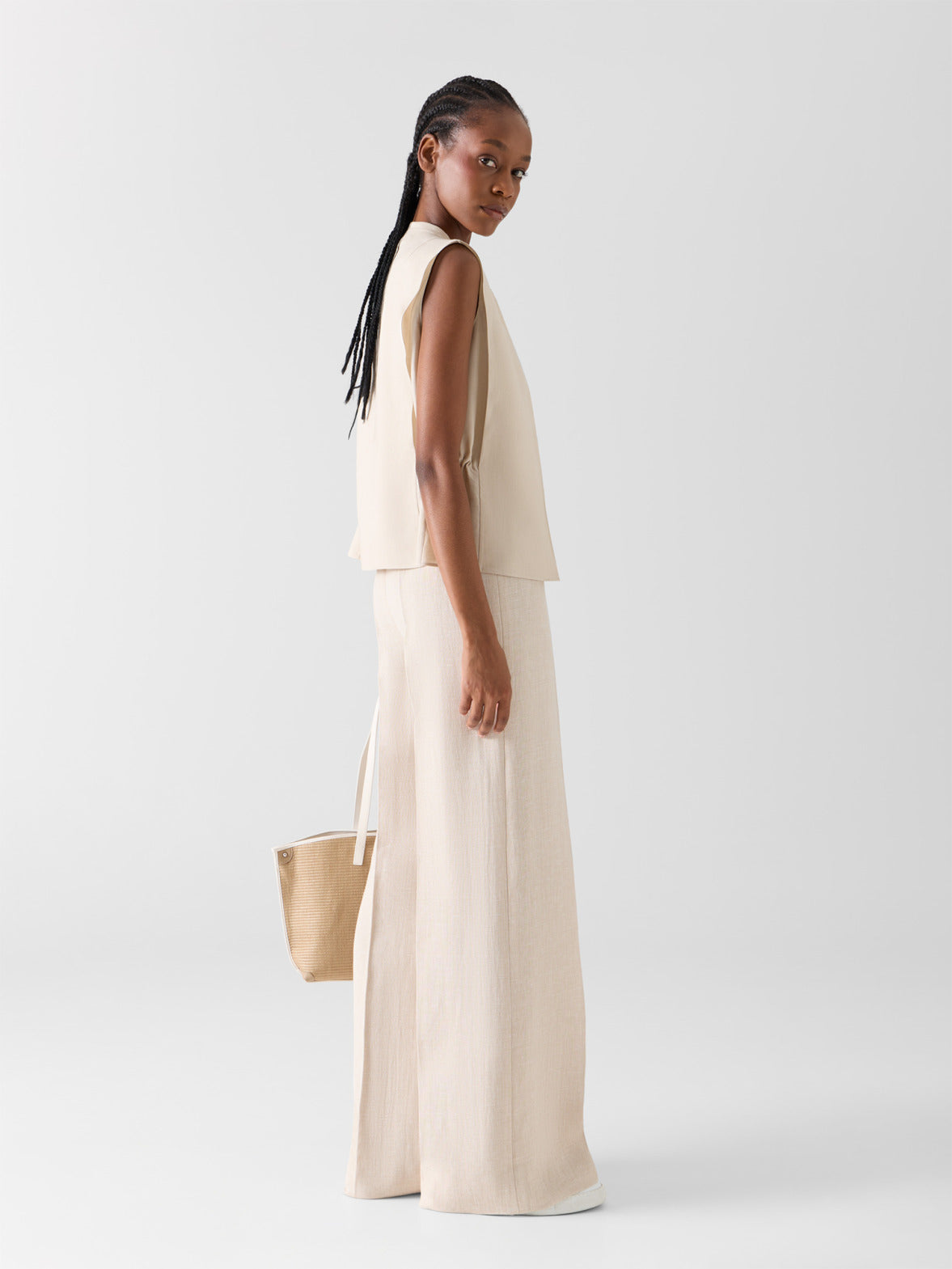 Minimalistisches Akris Frühjahr/Sommer Ensemble mit weiter Leinenhose und ärmellosem cremefarbenem Top. Fokus auf natürliche Texturen, fließende Schnitte und eine edle monochrome Ästhetik.