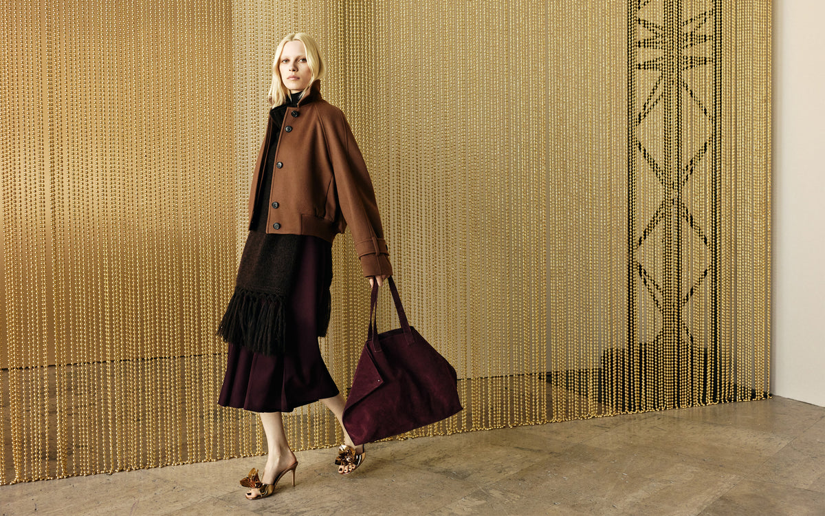 Look aus der Akris Fall 2026 Kollektion mit hochwertiger Strickmode, eleganter Outerwear und der ikonischen Ai Tasche in saisonalen Burgundertönen.