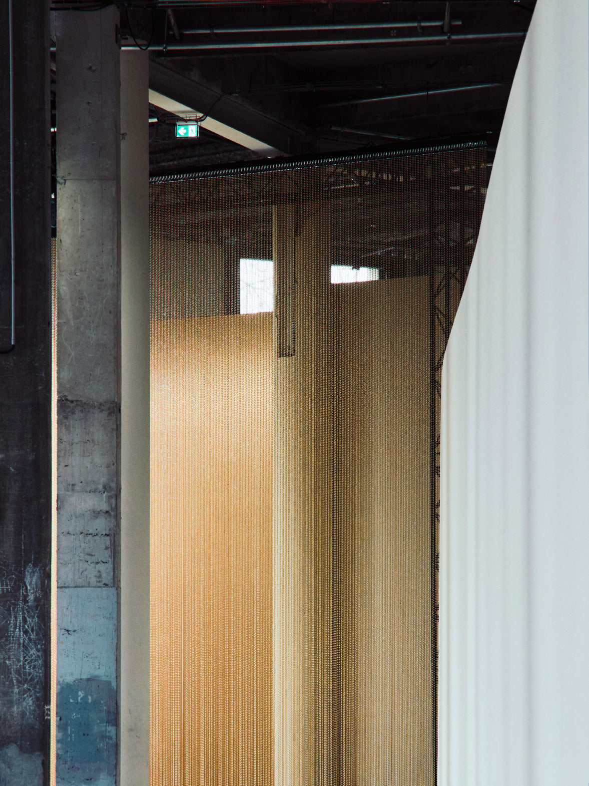 Eine Sammlung von Textilproben mit schimmernden Goldpailletten, kunstvollen Metallic-Webereien und einem zarten weißen Stoff mit dezentem Karomuster.