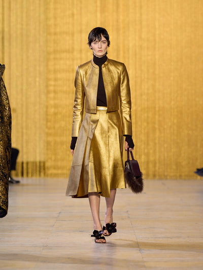 Eine Hommage an Olga de Amaral in der Akris FW26-Kollektion in Paris, geprägt von einem Dialog zwischen tiefem Schwarz, Burgunderrot und Goldakzenten.