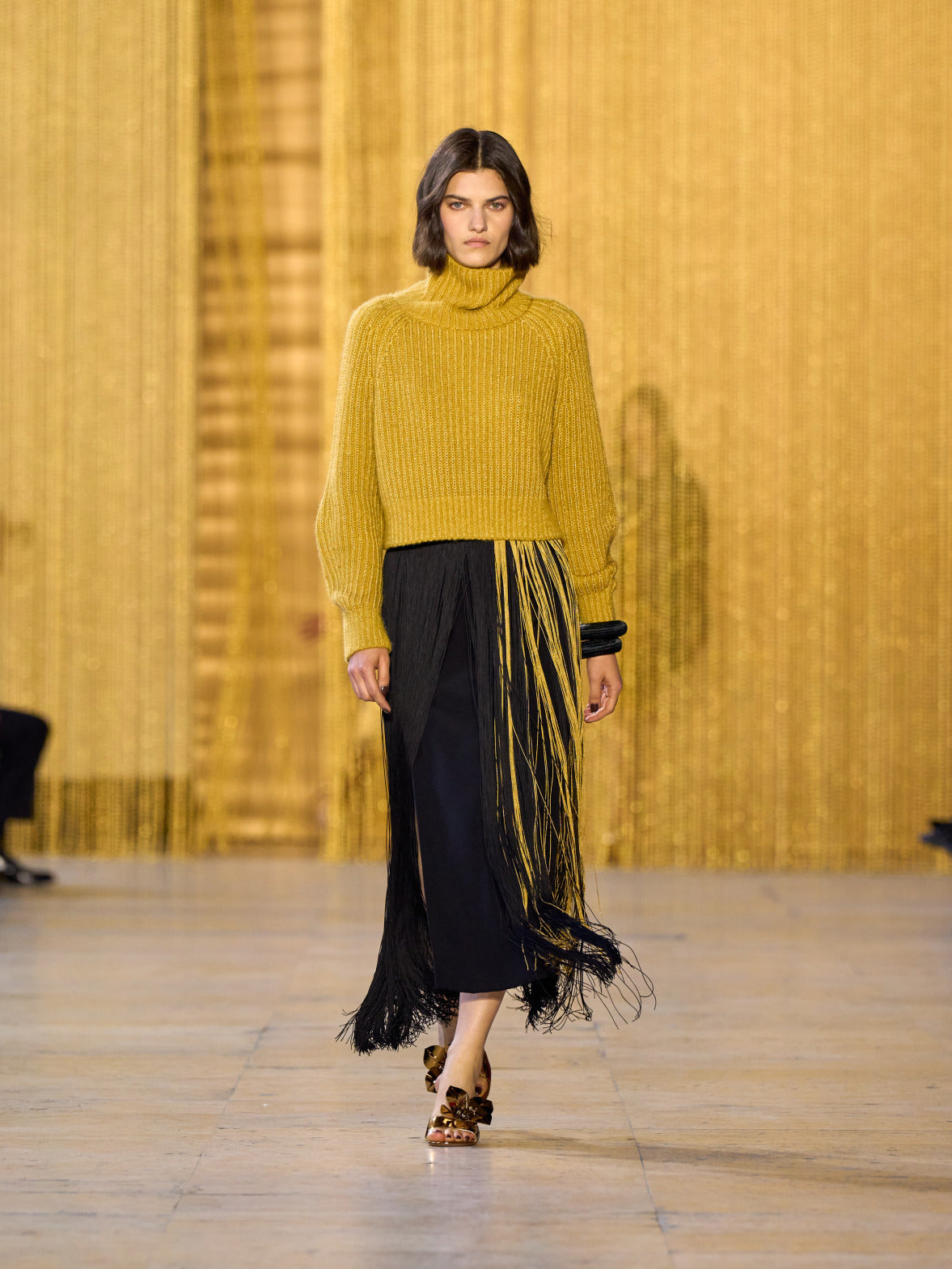 Eine Hommage an Olga de Amaral in der Akris FW26-Kollektion in Paris, geprägt von einem Dialog zwischen tiefem Schwarz, Burgunderrot und Goldakzenten.