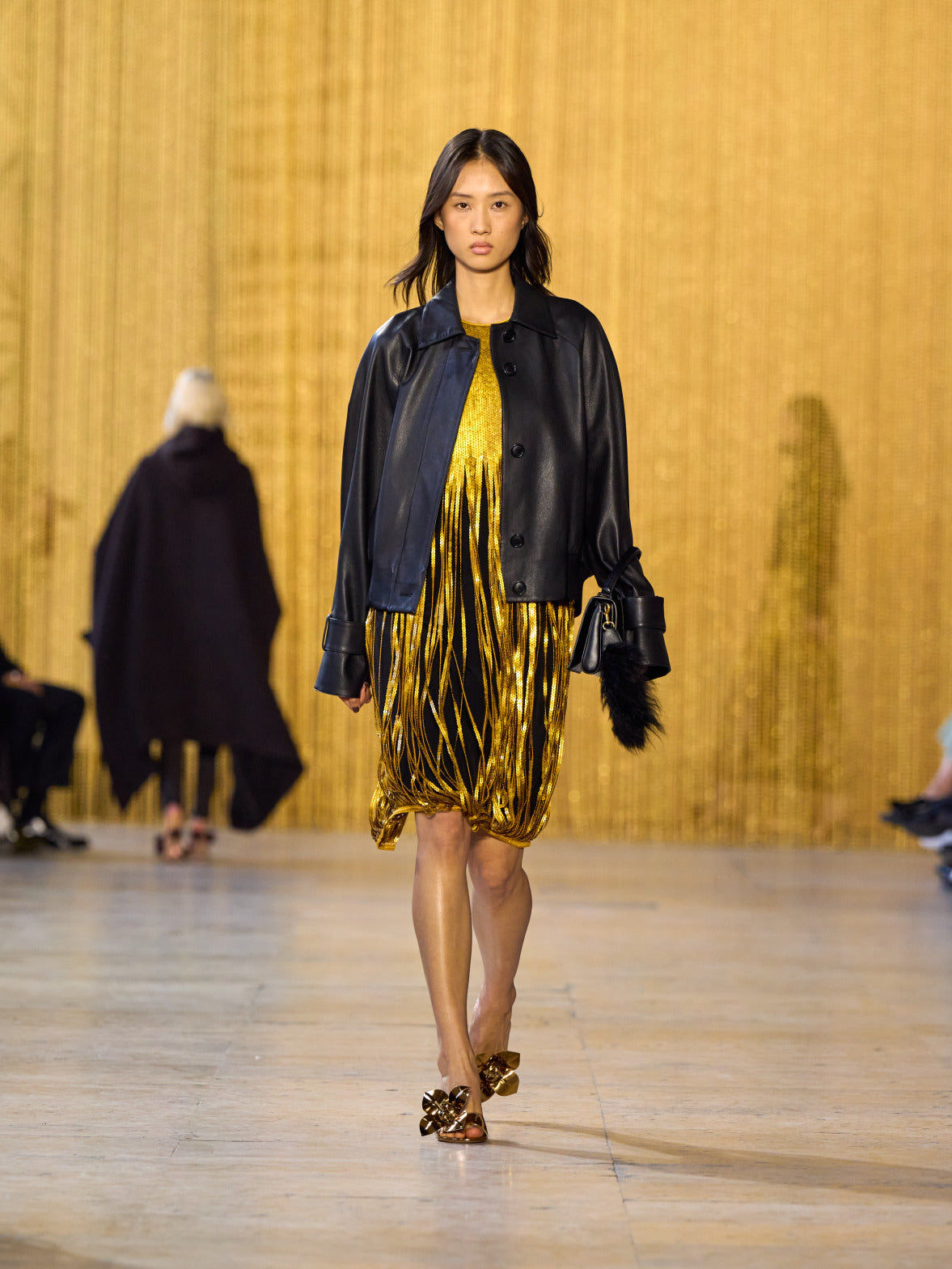 Eine Hommage an Olga de Amaral in der Akris FW26-Kollektion in Paris, geprägt von einem Dialog zwischen tiefem Schwarz, Burgunderrot und Goldakzenten.