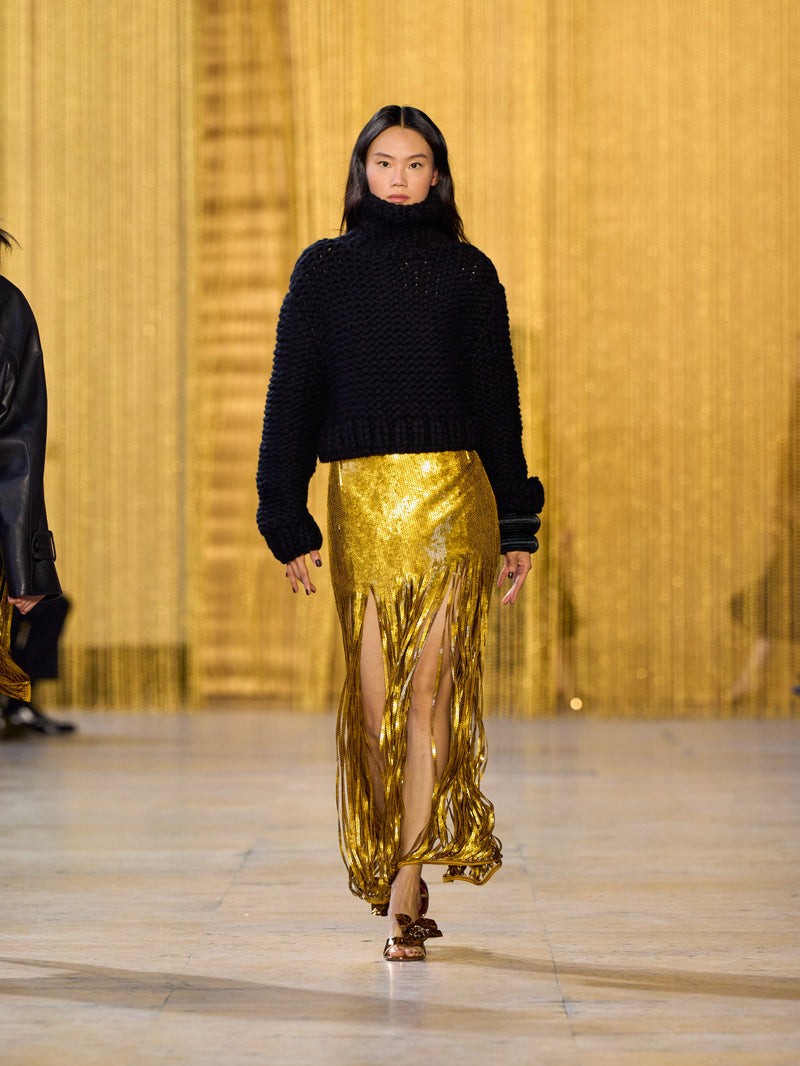 Eine Hommage an Olga de Amaral in der Akris FW26-Kollektion in Paris, geprägt von einem Dialog zwischen tiefem Schwarz, Burgunderrot und Goldakzenten.