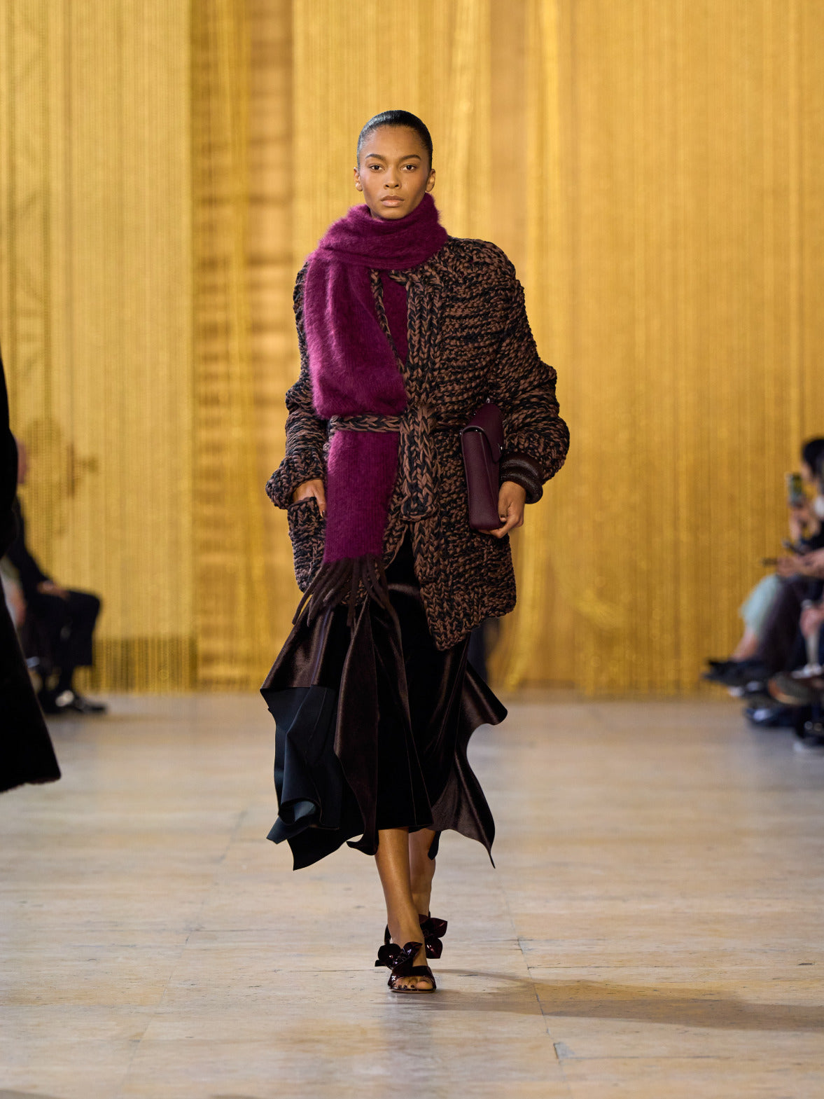 Eine Hommage an Olga de Amaral in der Akris FW26-Kollektion in Paris, geprägt von einem Dialog zwischen tiefem Schwarz, Burgunderrot und Goldakzenten.