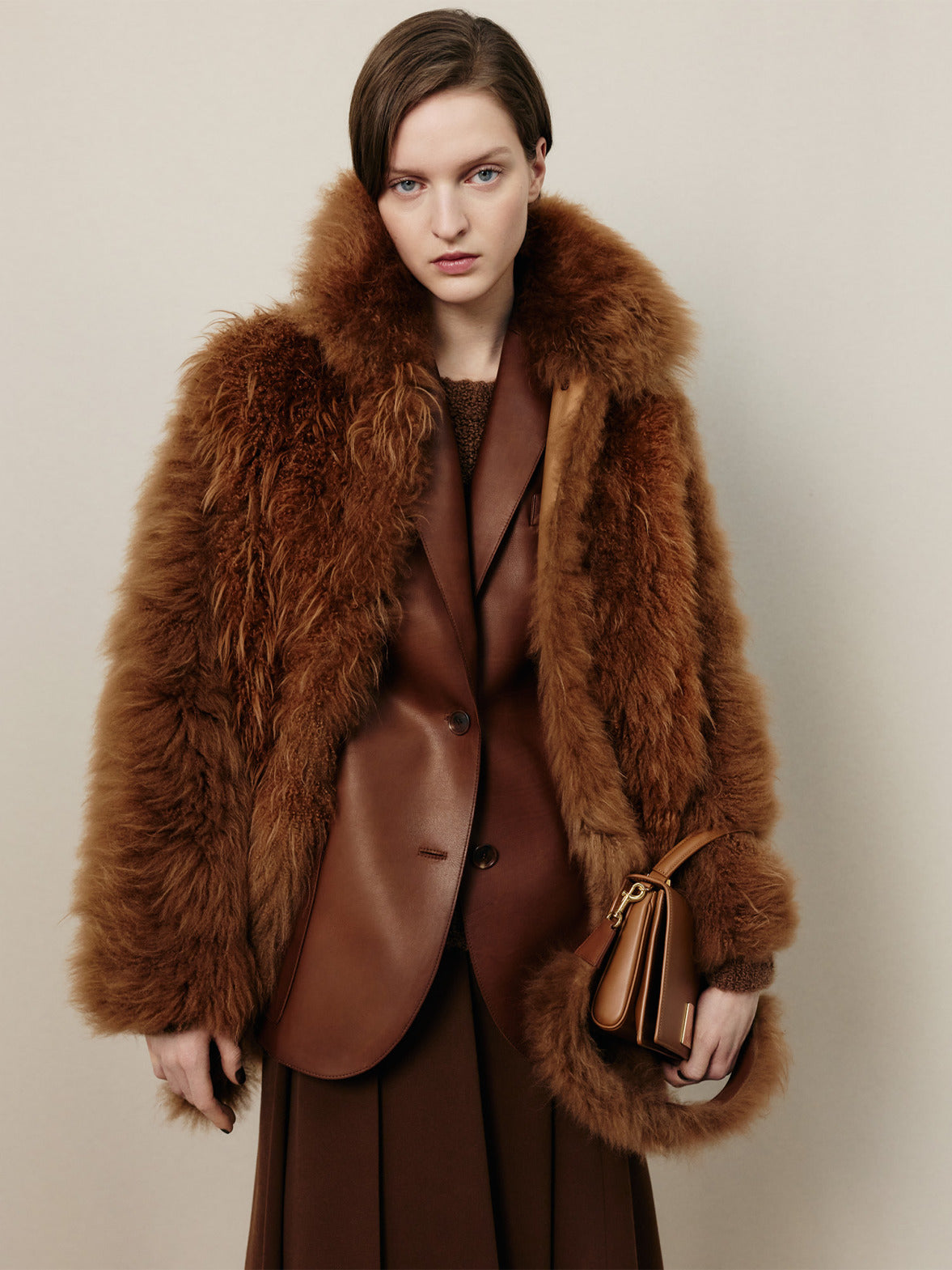 Akris Herbstkollektion 2026 mit braunem Fellmantel, Leder-Layering und der Alice Top Handle Bag in warmen Herbsttönen.
