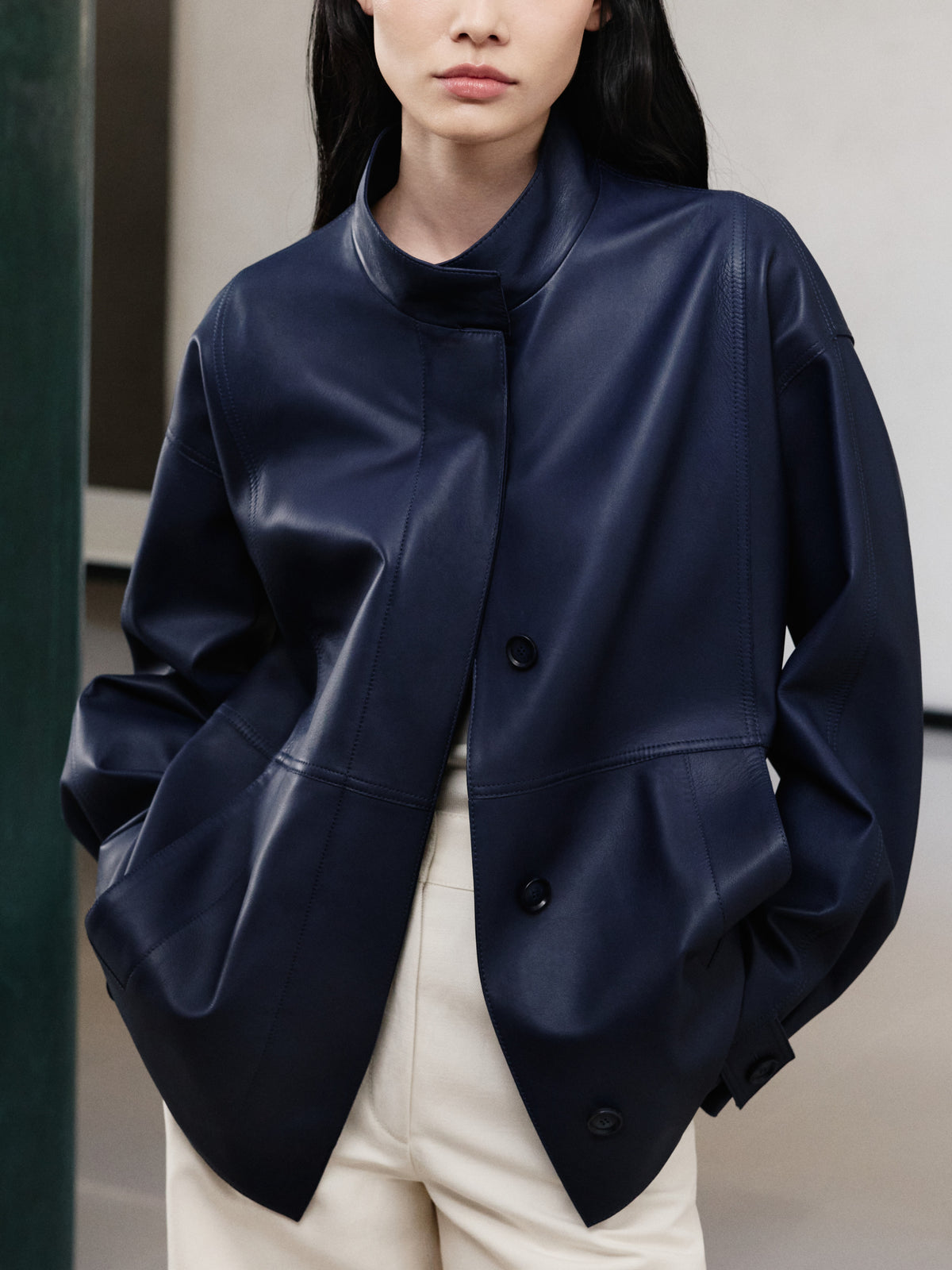 Erleben Sie moderne Schneiderkunst mit der Akris Pre-Fall Kollektion und einer luxuriösen Oversize-Lederjacke in tiefem Marineblau. Veredelt durch einen eleganten Stehkragen und strukturierte Nähte, kombiniert sie sich perfekt mit cremefarbenen Hosen. Entdecken Sie subtilen Luxus und höchste Schweizer Handwerkskunst.