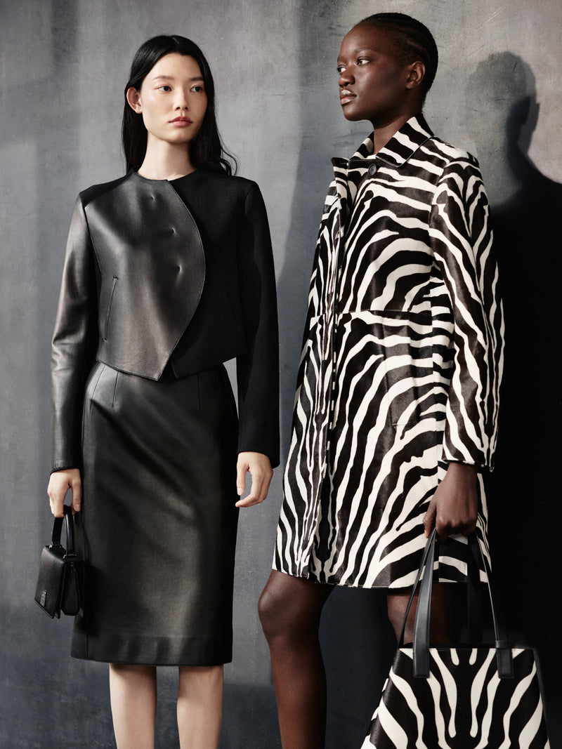 Entdecken Sie die ausdrucksstarken Kontraste der Akris Pre-Fall Kollektion mit einem skulpturalen Ensemble aus schwarzem Leder und einem ikonischen Mantel im Allover-Zebra-Print. Ergänzt werden die Looks durch die passenden Luxushandtaschen, wie die legendäre Ai und die elegante Anouk. Erleben Sie exzellente Schweizer Schneiderkunst für einen modernen Auftritt.