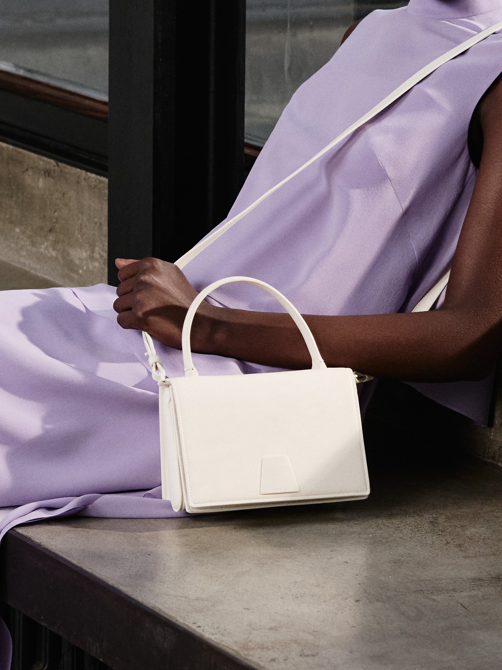 Erleben Sie mühelose Eleganz mit der Akris Pre-Fall Kollektion in einem zarten, monochromen Glyzinien-Violett. Ergänzen Sie das fließend drapierte Ensemble mit der minimalistischen, weißen Alice Handtasche. Entdecken Sie die perfekte Balance aus modernem Schneiderhandwerk und zeitlosem Luxus.