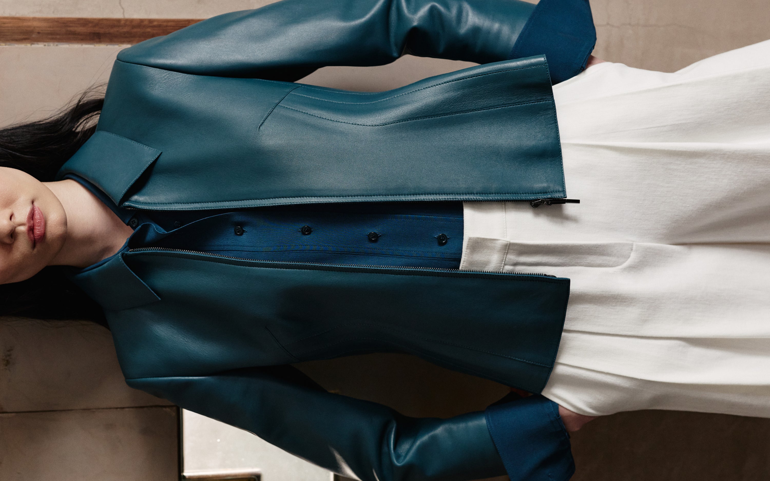 Entdecken Sie die anspruchsvolle Schneiderkunst der Akris Pre-Fall Kollektion mit einer luxuriösen Lederjacke im edlen Farbton Ottanio. Kombiniert mit einer eleganten, hochgeschnittenen weißen Hose entsteht unaufdringlicher Luxus. Erleben Sie fließende Linien und exzellente Schweizer Handwerkskunst.