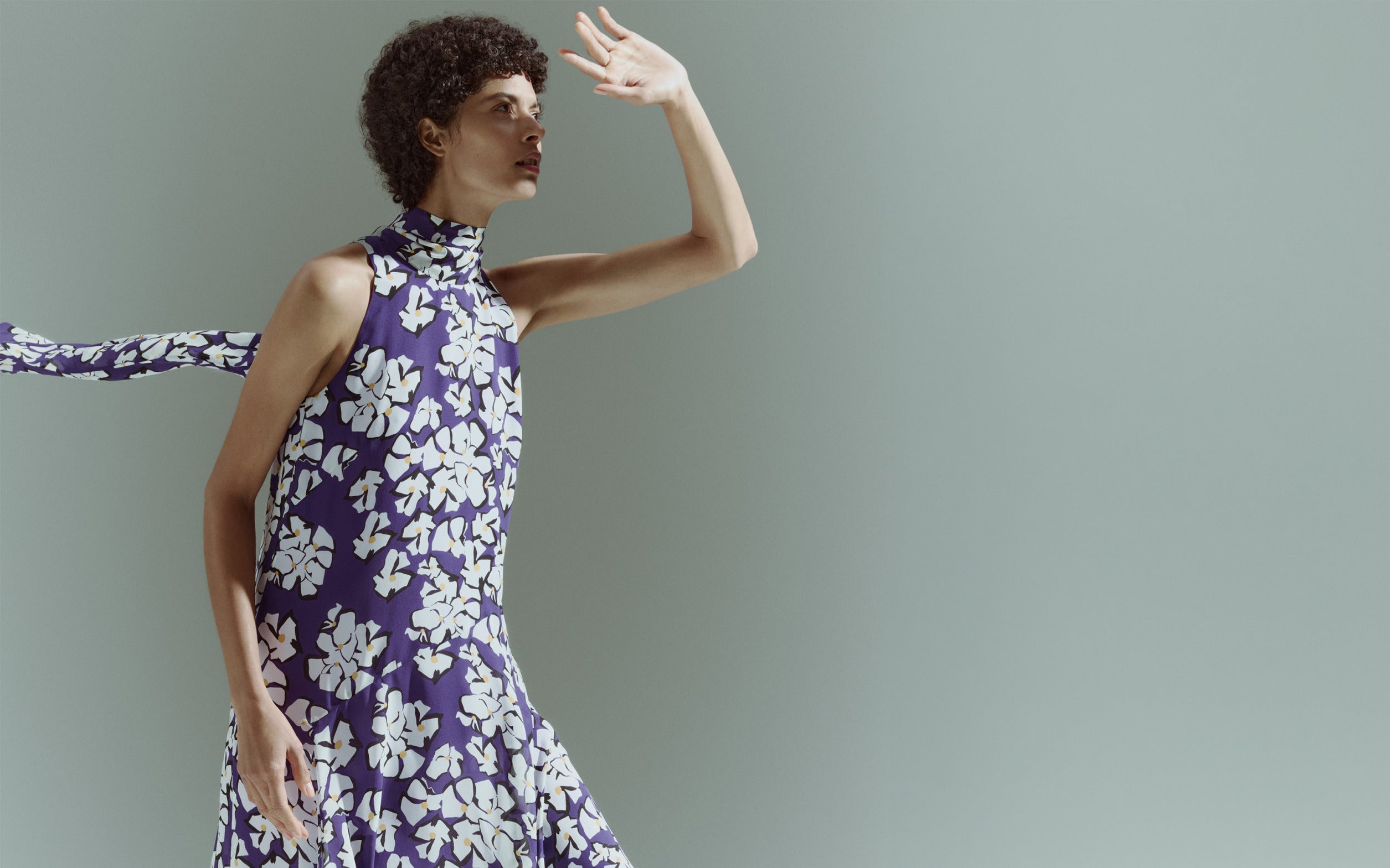 Model in einem ärmellosen Stehkragen-Top mit lila-weißem Blumenmuster aus der Akris punto Pre-Fall 2026 Kollektion.
