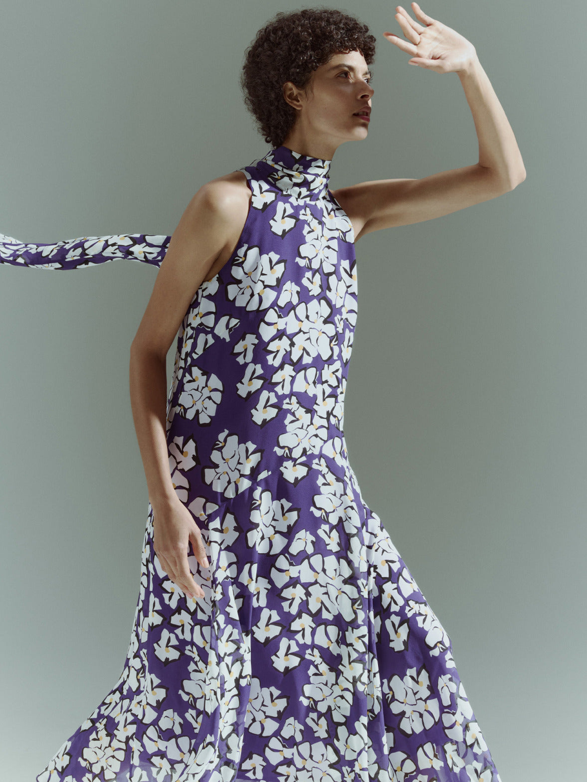 Model in einem ärmellosen Stehkragen-Top mit lila-weißem Blumenmuster aus der Akris punto Pre-Fall 2026 Kollektion.